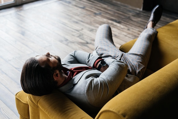 Lonely handsome man resting on sofa