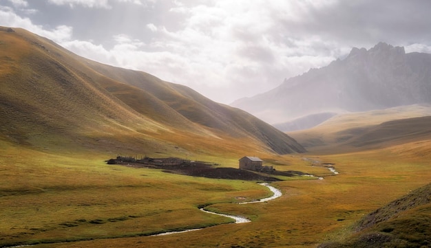 Foto la casa solitaria di un pastore di pecore o di cavalli nelle belle montagne autunnali del kirghizistan, nella valle di aksai, nella regione di naryn