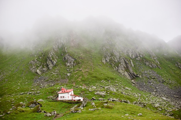 Сиротливый дом в горах Fagaras долины, Трансильвания, Румыния, Европа. Горы покрыли туманом.