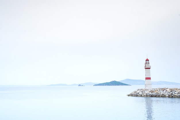 写真 山と霧の景色を望む海の真ん中にある石の道の孤独な灯台