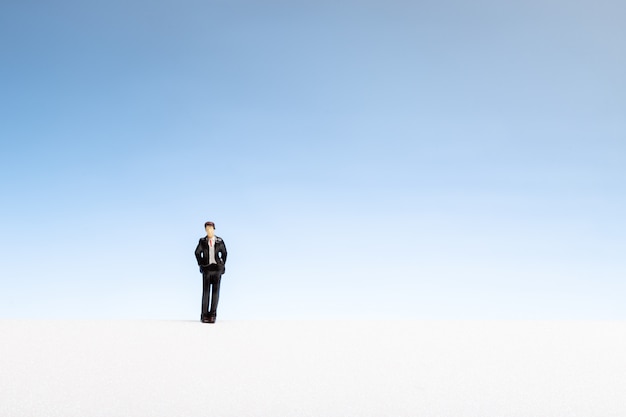 Lonely man concept. Man miniature on gradient copyspace