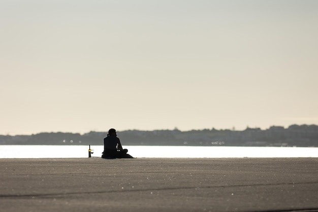 A lonely man drinking wine at the waterfront