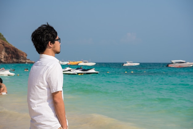 lonely man is walking on beach at sea.