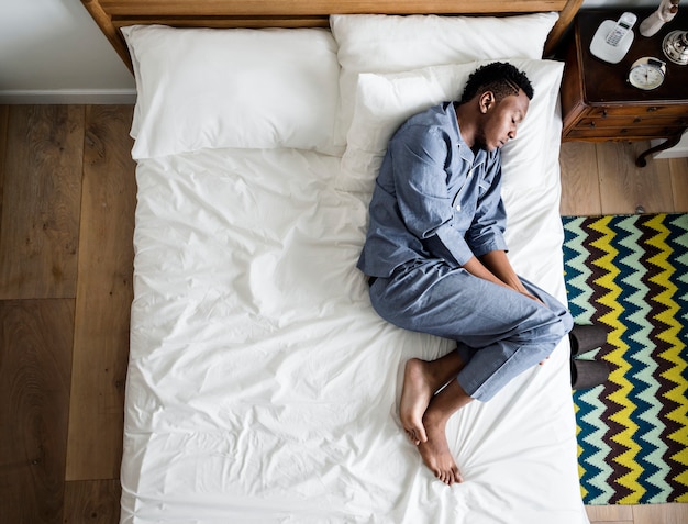 Lonely man sleeping alone on the bed