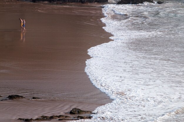 Le persone sole camminano sulla spiaggia