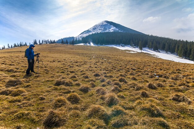 Одинокий фотограф в горах с фотоаппаратом