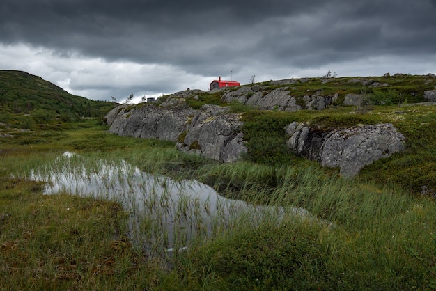 Casa rossa solitaria (doppia) tra tundra e pietre. natura settentrionale della penisola di kola