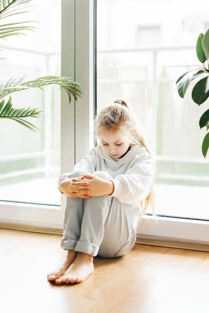 Lonely sad girl near the window