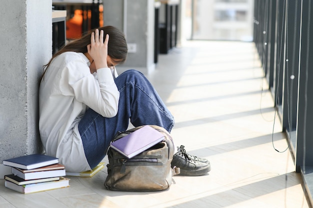 クラスメイトが彼女の社会的排除の問題を無視している間,孤独で悲しい女子学生 学校でのいじめの概念