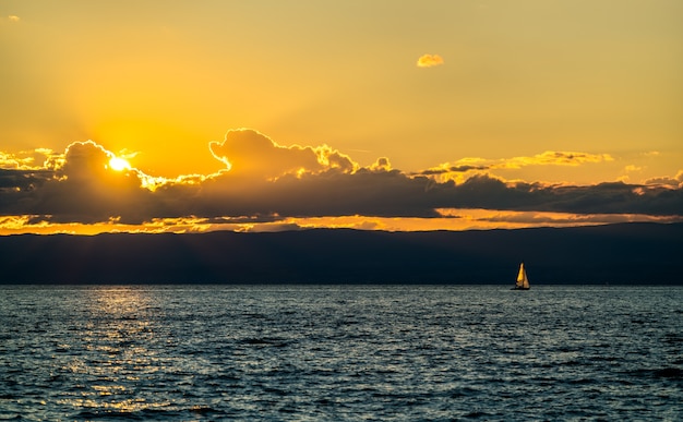 Lonely sailing yacht on Lake Geneva at sunset in Switzerland