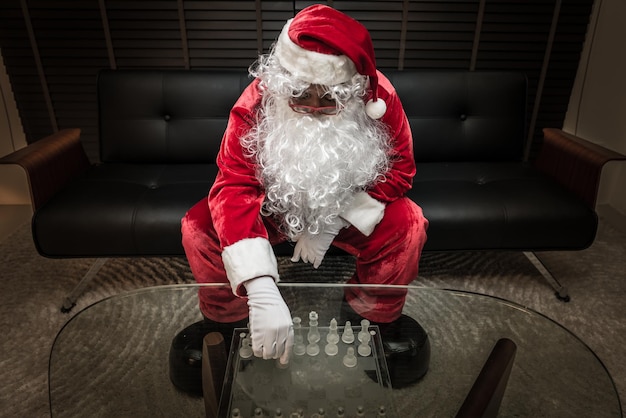 Lonely Santa Claus playing chess alone with sadness