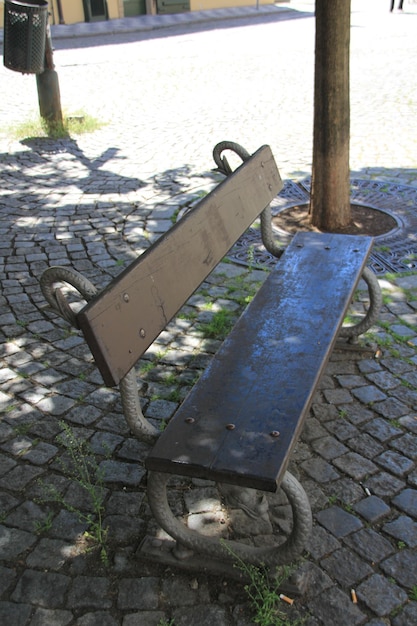 Одинокая одинокая скамейка в парке или сиденье в тени ветвей