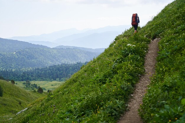 Photo a lonely traveler goes uphill with a backpack to find his limits