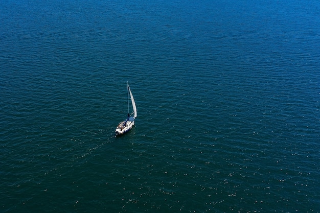 Фото Одинокая белая парусная яхта в море, вид с воздуха, стрельба с дрона