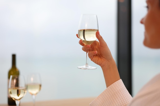 Lonely woman drinks wine alone in hotel room