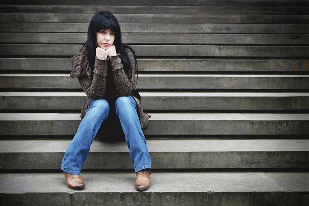 Фото Одинокая женщина сидит на ступеньках