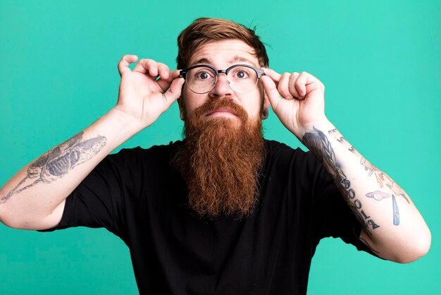 Long beard and red hair cool man wearing a simple shirt and with a copy space