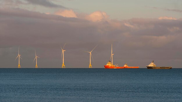 Long-distance view of offshore windfarm with support vessel