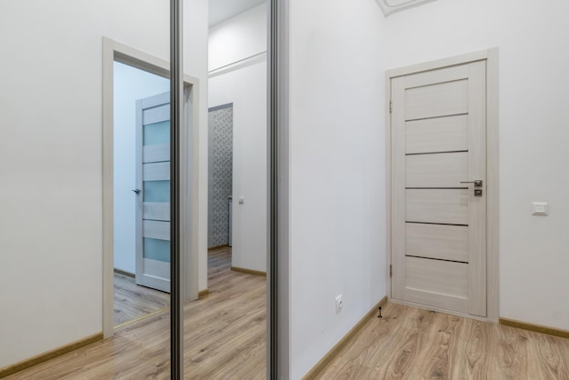 Long empty corridor in interior of entrance hall of modern\
apartments office or clinic with many doors