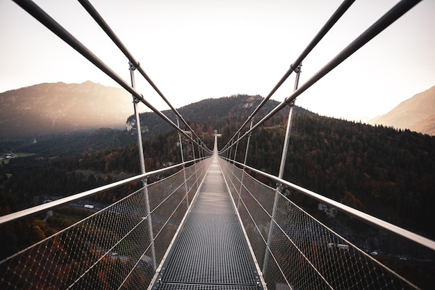 Photo long empty footbridge against clear sky during sunrise