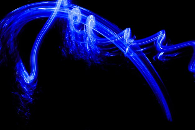 Photo long exposure of a blue light in a black background