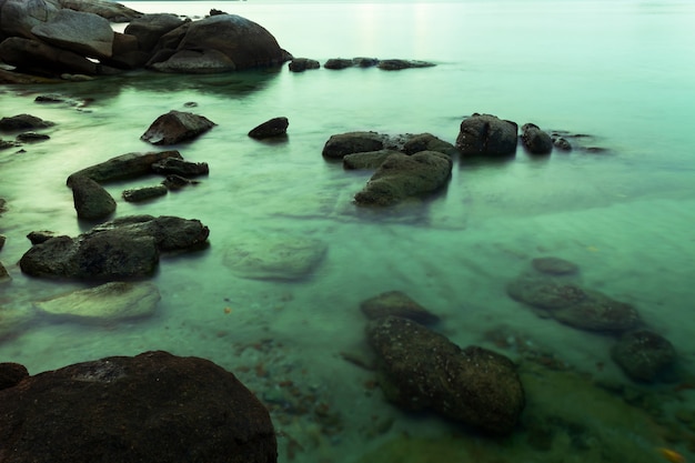 Изображение с длинным вырезом камней в фоне пейзажей в море