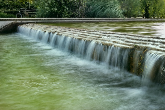 Long exposure image of a small slope with water falling into a canal
