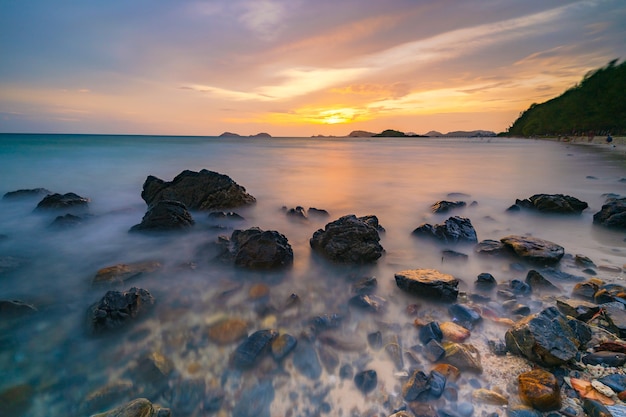 Long exposure shot of rocks on the sea at sunset