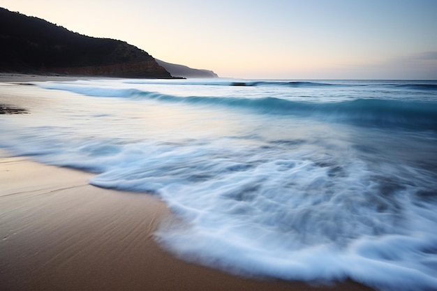 Long exposure of a wave breaking on the sandy beach at sunset