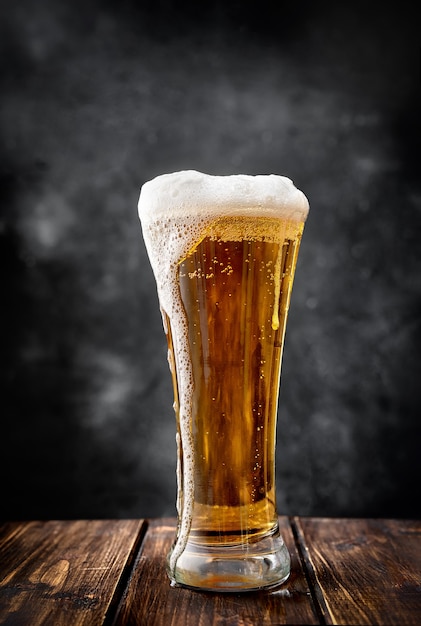 暗い背景にビールの長いガラス