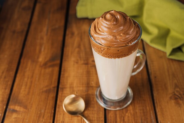 Un lungo bicchiere di delizioso dalgona coffee catturato dall'alto