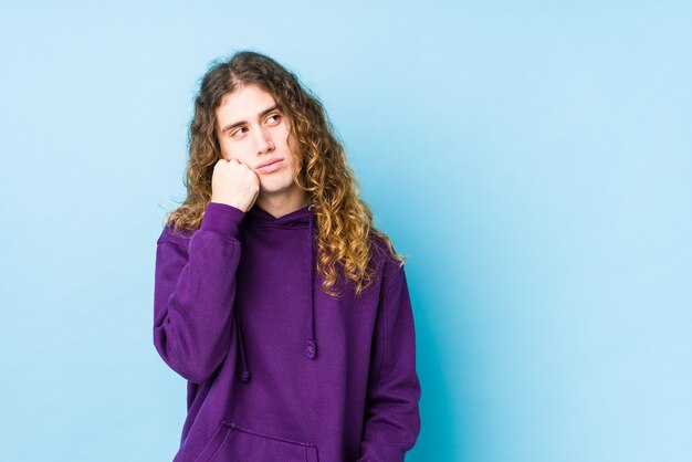 Long hair man posing isolated who feels sad and pensive, looking at copy space.