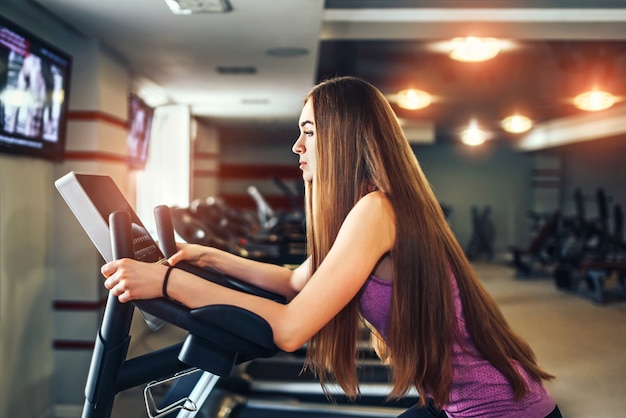 Long hair pretty girl training in the gym