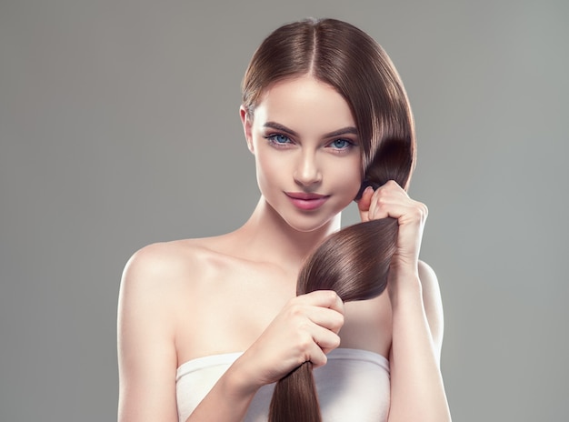 Длинные волосы женщина рука трогательно волосы гладкая брюнетка прическа модель