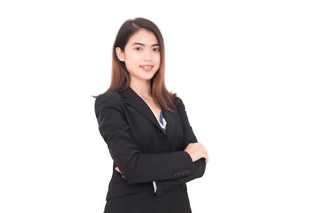 Long haired Asian Thai woman wearing a long black suit, she is looking at the camera smiling and crossing her arms against a white background.