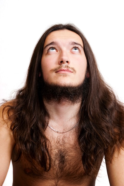 Uomo con i capelli lunghi e la barba che guarda in alto