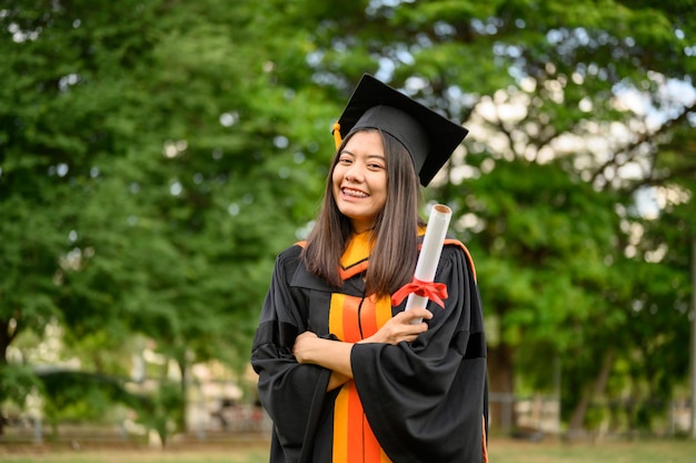 大学で卒業の喜びを表現する黒いフリルのドレスを着ている長い髪の女子学生。