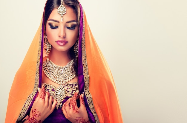 Foto donna orientale dai capelli lunghi con tatuaggi all'henné mehndi sulle mani