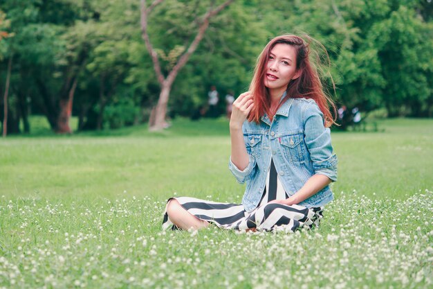 A long haired woman sitting in the lawn