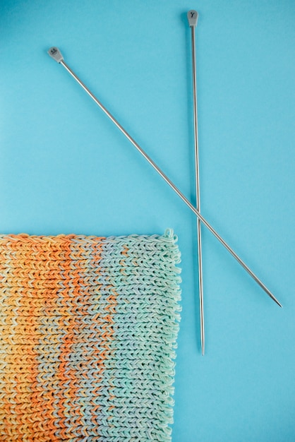いくつかの編みでライトブルーの背景にロングアイロン編針。