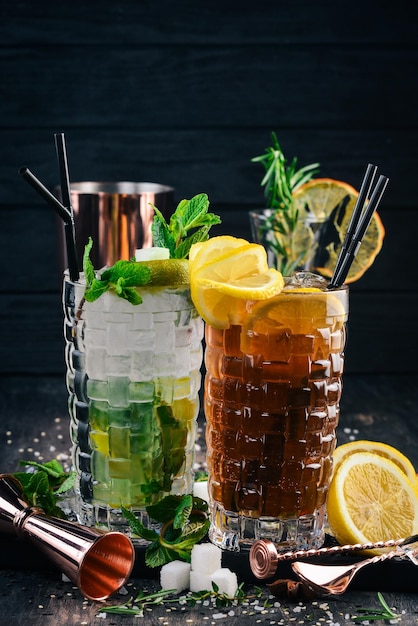 Long Island en Mojito alcoholische cocktails op een zwarte houten achtergrond