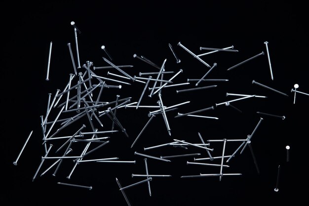 Фото Длинные гвозди летают в воздухе многие группы винтовых гвоздей короткие длинные металлические падения в качестве строительного инструмента