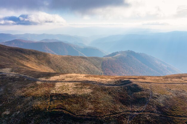 青い空の下で山に沿って走る長い小道