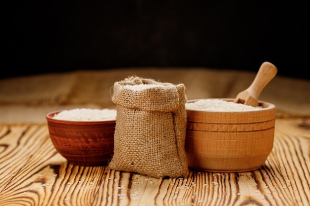 Long polished rice in bowls and bags on a wooden background High quality photo