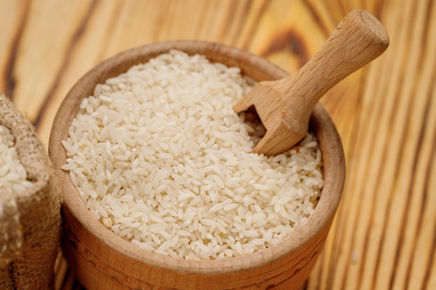 Long polished rice in bowls and bags on a wooden background High quality photo