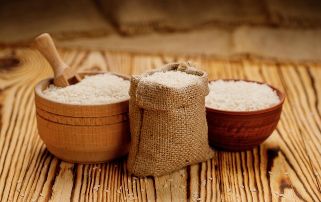 Long polished rice in bowls and bags on a wooden background High quality photo