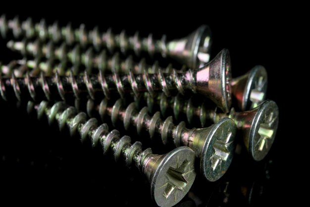 Long screws for a screwdriver on a black background close-up macro photography