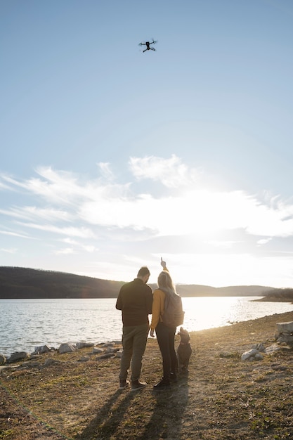 Photo long shot couple with cute dog outside