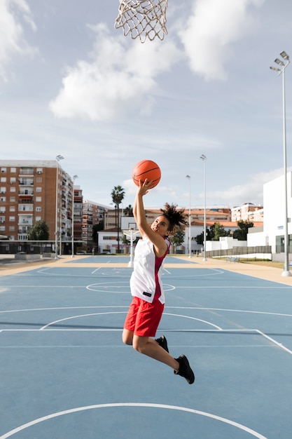 Foto colpo lungo della ragazza che gioca a pallacanestro