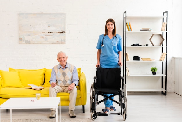 Long shot nurse holding a wheelchair for old man